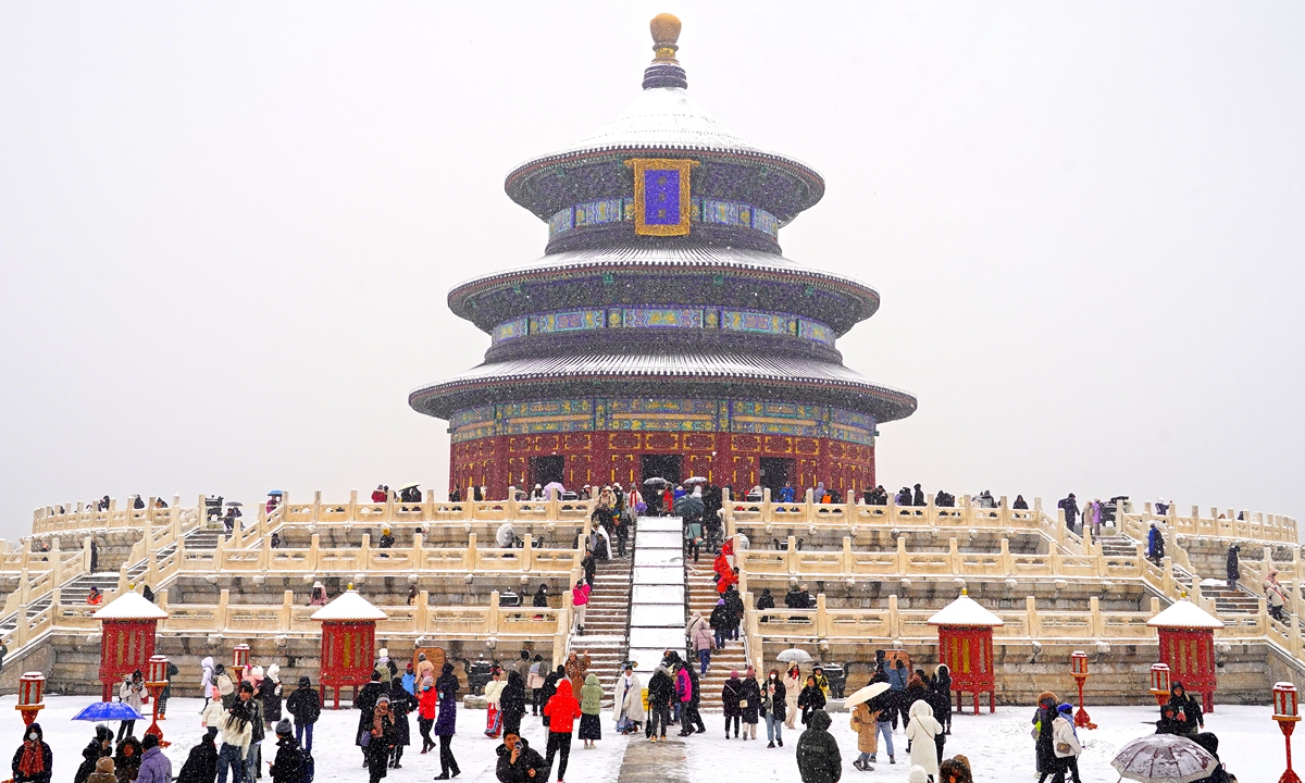 People visit Tiantan (Temple of Heaven) Park in Beijing, capital of China in snow on December 13, 2023. China's meteorological authority on Wednesday renewed a yellow alert for blizzards, forecasting intense snowfall in the north of the country.Photo:VCG