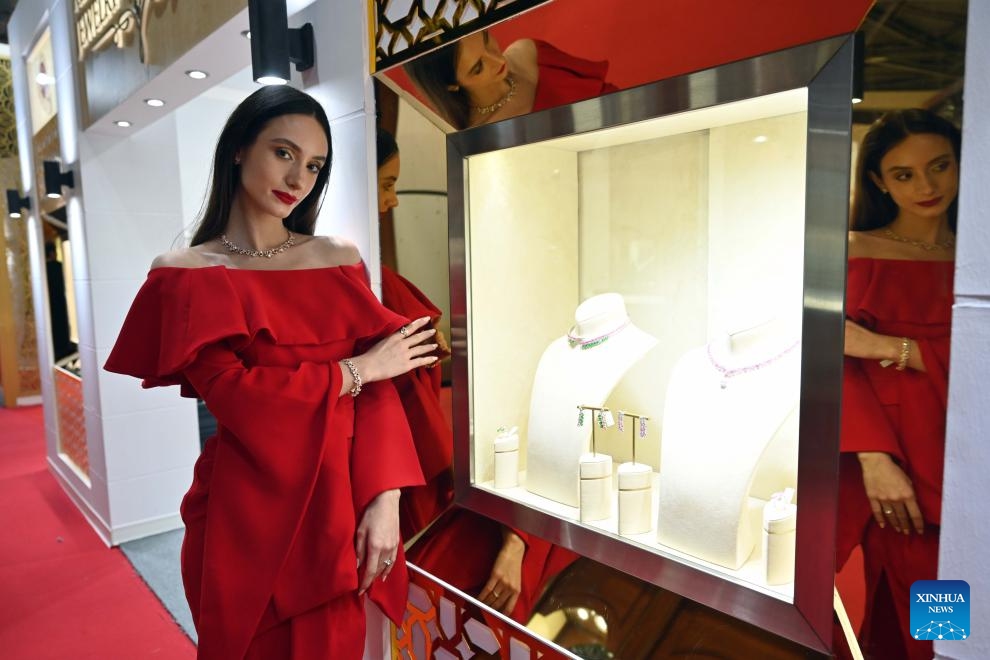 A woman presents jewelry at the International Gold and Jewelry Exhibition in Hawalli Governorate, Kuwait, on Dec. 13, 2023. The International Gold and Jewelry Exhibition kicked off here on Wednesday and will last until Dec. 18 with the participation of more than 200 exhibitors. (Photo: Xinhua)