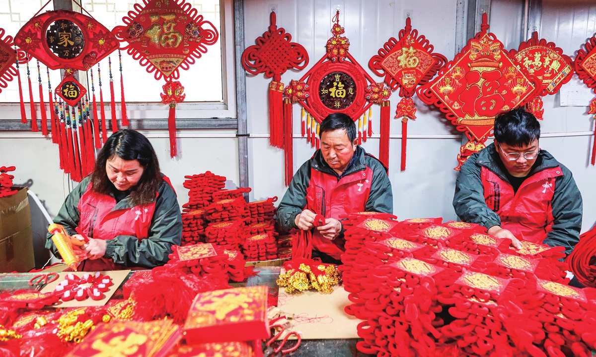 Workers rush to fill orders for Chinese knot products to meet the market demand for the upcoming New Year's Day and the Spring Festival at a handicraft processing factory in Suqian, East China's Jiangsu Province on December 14, 2023. During these holidays, products with Chinese elements are popular among Chinese consumers. Photo: VCG
