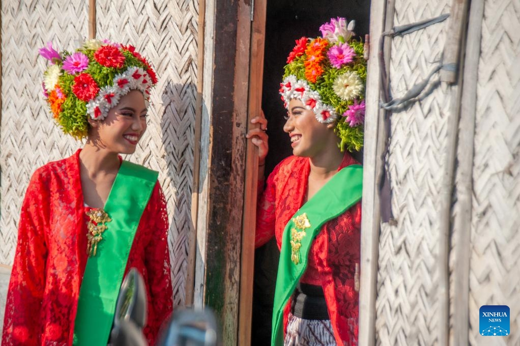 Girls decorated with flowers on their heads interact with each other before participating in a celebration for the traditional Ngarot festival at Lelea village in Indramayu district, West Java, Indonesia, on Dec. 13, 2023. Ngarot is a traditional ceremony in Indramayu of West Java Province held to welcome the rice planting season.(Photo: Xinhua)