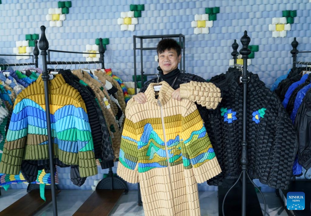 A costume designer presents a piece of his down garment works in Pinghu City, east China's Zhejiang Province, Dec. 14, 2023. Winter is the peak season for the down garment industry, which has gone through rapid development in Pinghu in recent years. In 2022, the down garment shipment volume of Pinghu was almost 200 million and the sales volume has exceeded 40 billion yuan (about 5.6 billion U.S. dollars).(Photo: Xinhua)