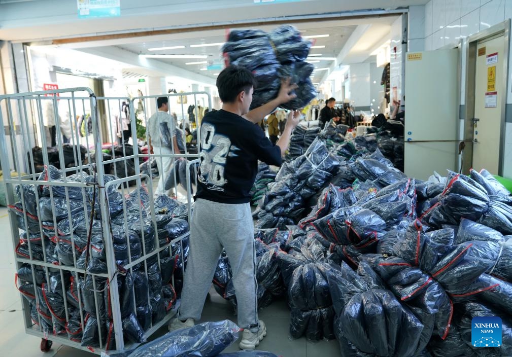 A seller arranges down garments to be shipped at a clothing mall in Pinghu City, east China's Zhejiang Province, Dec. 14, 2023. Winter is the peak season for the down garment industry, which has gone through rapid development in Pinghu in recent years. In 2022, the down garment shipment volume of Pinghu was almost 200 million and the sales volume has exceeded 40 billion yuan (about 5.6 billion U.S. dollars).(Photo: Xinhua)