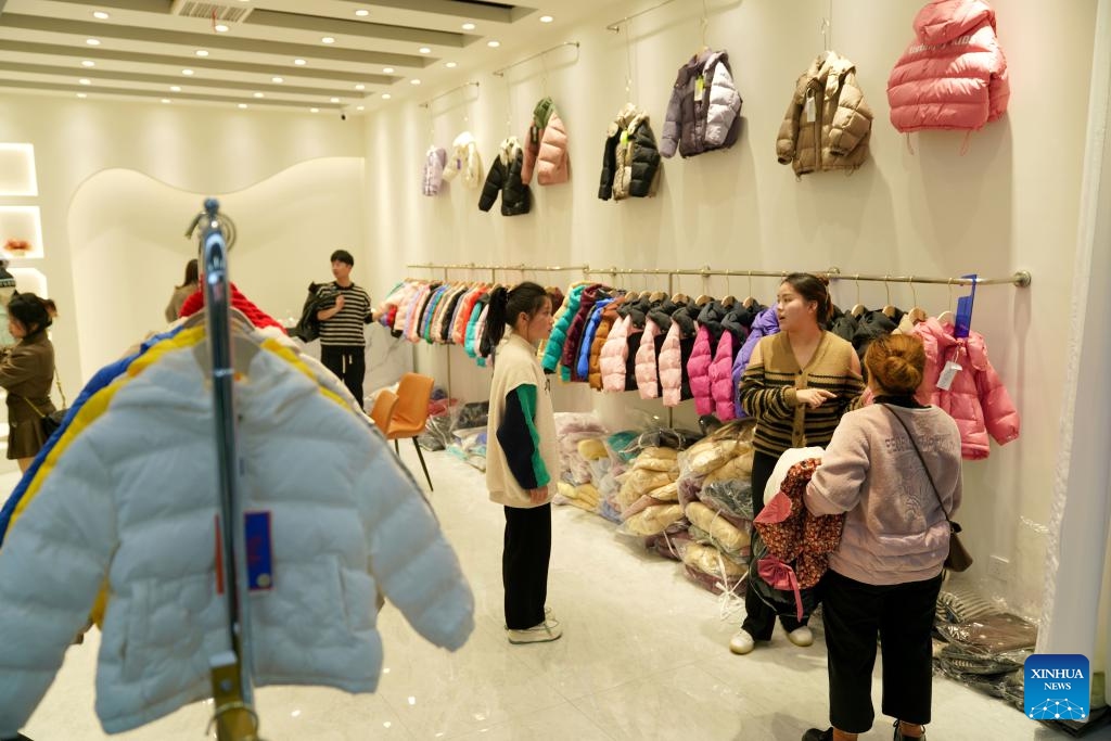 Customers select down garments for children at a clothing mall in Pinghu City, east China's Zhejiang Province, Dec. 14, 2023. Winter is the peak season for the down garment industry, which has gone through rapid development in Pinghu in recent years. In 2022, the down garment shipment volume of Pinghu was almost 200 million and the sales volume has exceeded 40 billion yuan (about 5.6 billion U.S. dollars).(Photo: Xinhua)