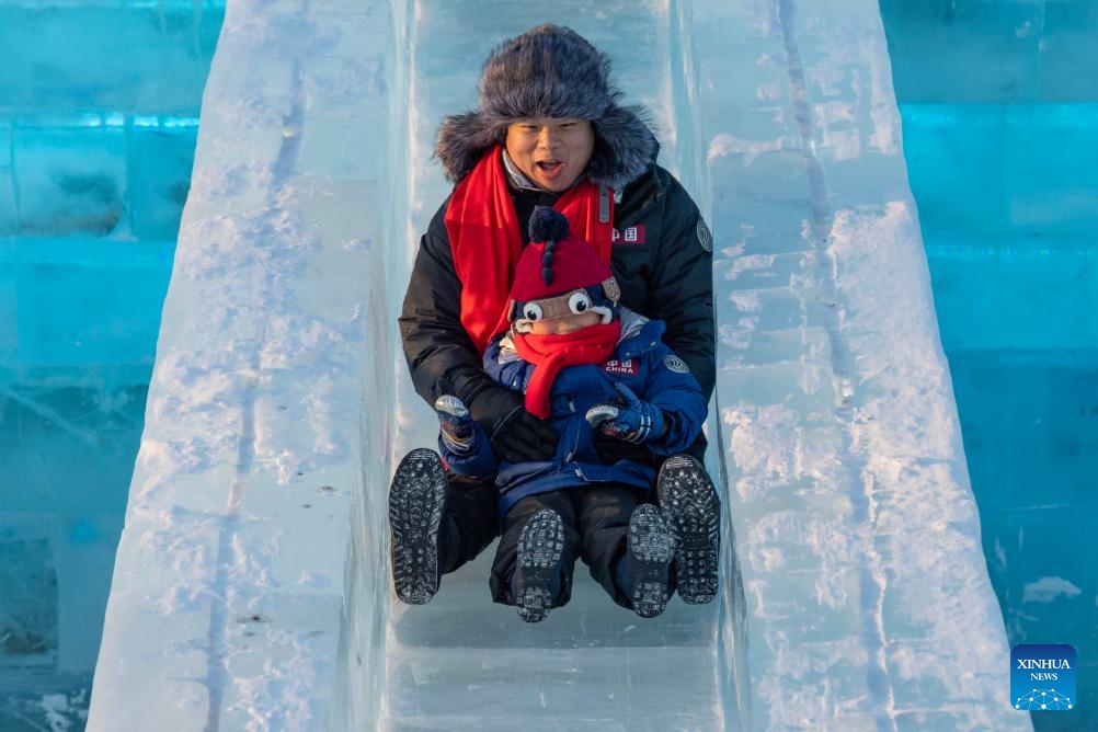 Tourists have fun at the Harbin Ice-Snow World in Harbin, northeast China's Heilongjiang Province, Dec. 18, 2023. The renowned Harbin Ice-Snow World opened to the public on Monday. Over 1,000 appealing ice and snow landscapes and sculptures have been built in the park for people to enjoy. The park aims to integrate arts, culture, performance, architecture and sports to showcase the charm of ice and snow.(Photo: Xinhua)