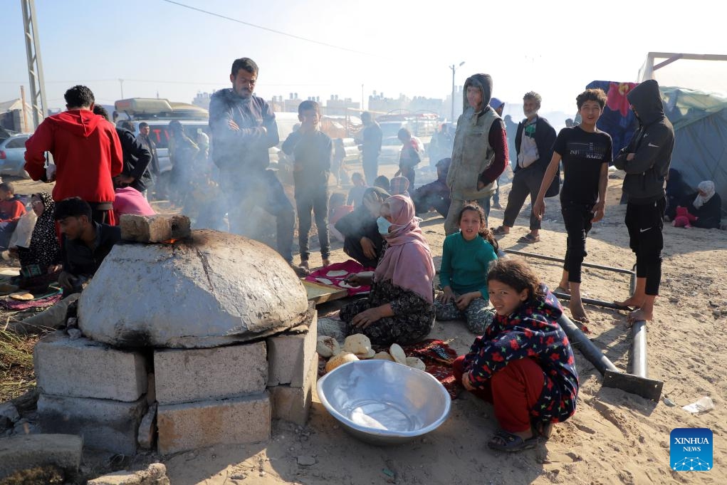 Displaced Palestinians prepare food at a temporary shelter in the southern Gaza Strip city of Rafah, on Dec. 18, 2023. UN officials and aid agencies have raised alarms about a humanitarian crisis in Gaza, including mass starvation and disease, as a vast majority of the region's 2.3 million people have been displaced during the ongoing two-month conflict.(Photo: Xinhua)