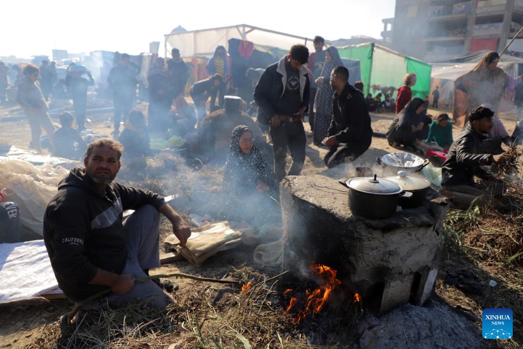 Displaced Palestinians prepare food at a temporary shelter in the southern Gaza Strip city of Rafah, on Dec. 18, 2023. UN officials and aid agencies have raised alarms about a humanitarian crisis in Gaza, including mass starvation and disease, as a vast majority of the region's 2.3 million people have been displaced during the ongoing two-month conflict.(Photo: Xinhua)