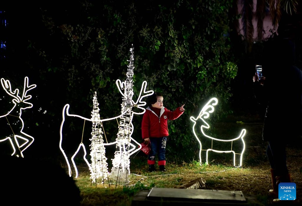 A child stands among festive decorations in Damascus, Syria, on Dec. 19, 2023.（Photo: Xinhua)