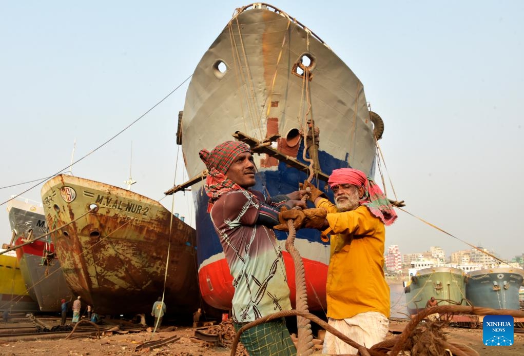 Laborers work at a shipyard in Keraniganj on the outskirts of Dhaka, Bangladesh, Dec. 17, 2023. Shipyard workers here are busy with winter work that is dismantling the cargo ships and cruisers which are no longer in use to reuse their parts in new or repaired ones.（Photo: Xinhua)