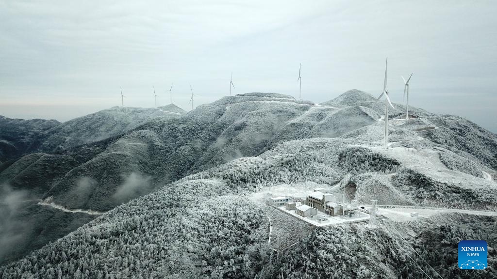 This aerial photo taken on Dec. 19, 2023 shows power facilities on Xihuang Mountain on the border between Zhijiang Dong Autonomous County and Mayang Miao Autonomous County of Huaihua, central China's Hunan Province. Due to the recent strong cold wave sweeping across Hunan Province, some power transmission lines crossing Xihuang Mountain experienced icing. Power supply technicians have been conducting daily inspections and maintenance work on power transmission facilities to ensure a reliable power supply.（Photo: Xinhua)