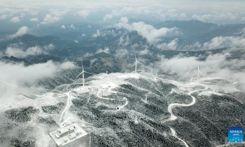 This aerial photo taken on Dec. 19, 2023 shows power facilities on Xihuang Mountain on the border between Zhijiang Dong Autonomous County and Mayang Miao Autonomous County of Huaihua, central China's Hunan Province. Due to the recent strong cold wave sweeping across Hunan Province, some power transmission lines crossing Xihuang Mountain experienced icing. Power supply technicians have been conducting daily inspections and maintenance work on power transmission facilities to ensure a reliable power supply.（Photo: Xinhua)