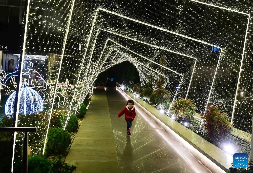 A child runs through festive decorations in Damascus, Syria, on Dec. 19, 2023.（Photo: Xinhua)