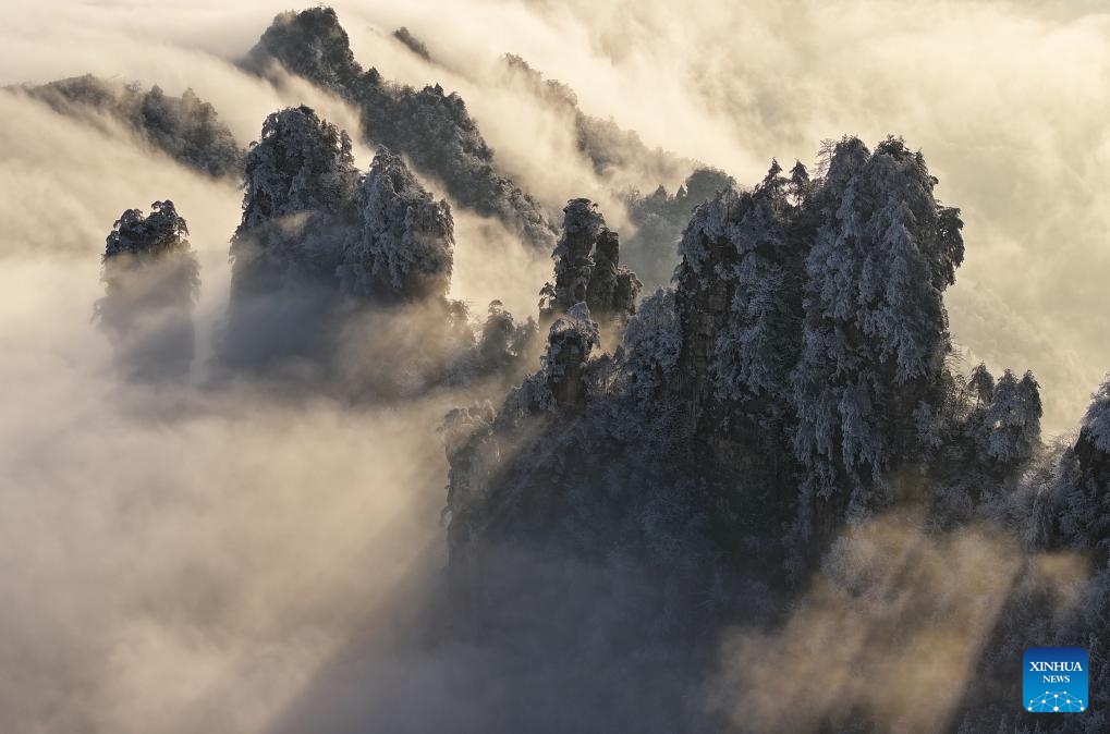 This aerial photo taken on Dec. 19, 2023 shows mountains amid mist after a snowfall in a national forest park of Zhangjiajie, central China's Hunan Province.（Photo: Xinhua)