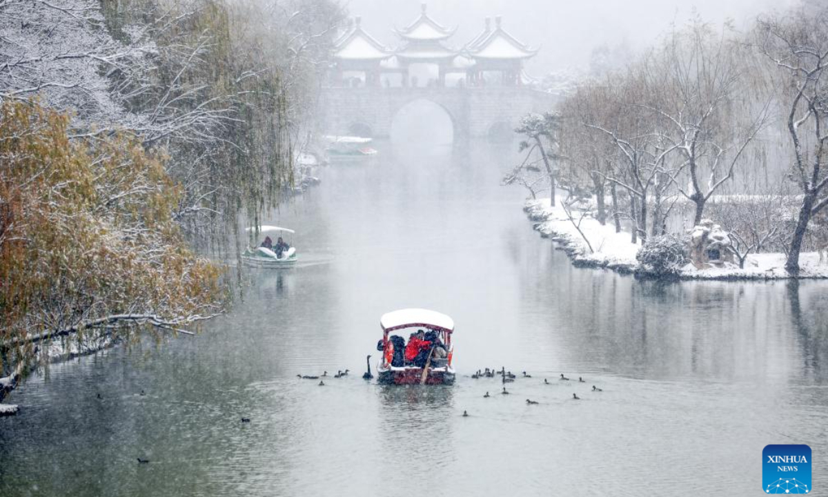 Tourists enjoy themselves on a boat at the Slender West Lake scenic spot in Yangzhou, east China's Jiangsu Province, Dec 18, 2023. A rendezvous with snow refreshes the landscapes as winter leaves its steps in most parts of China. Photo:Xinhua