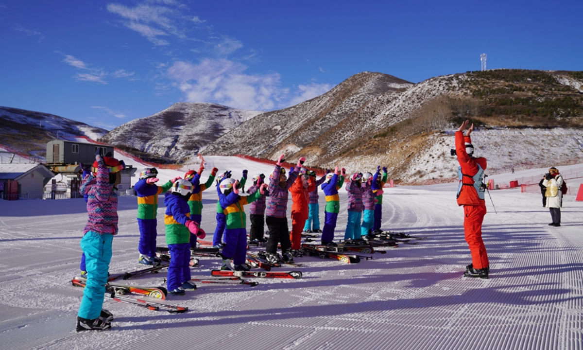 Elementary school students do warm-up exercises under the guidance of a coach at a ski resort in Liangcheng county, Ulanqab, north China's Inner Mongolia Autonomous Region. (Photo: People’s Daily Online)
