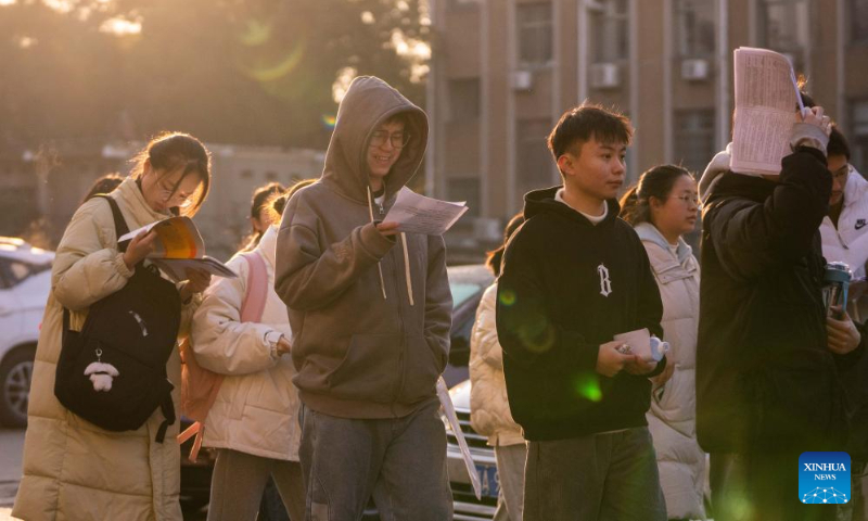 Examinees queue up to enter the examination site of the postgraduate admission exam in Hunan Agricultural University in Changsha, central China's Hunan Province, Dec. 23, 2023. (Xinhua/Chen Sihan)