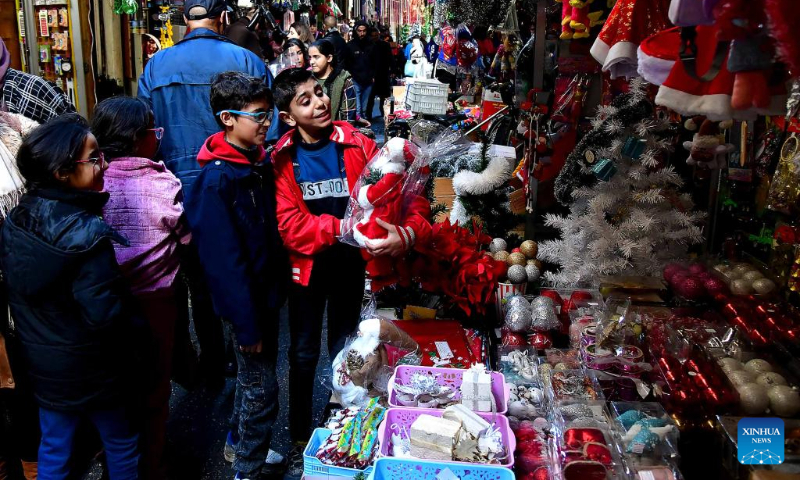 People are seen at a market of Christmas decorations in Damascus, Syria, Dec. 23, 2023. (Photo by Ammar Safarjalani/Xinhua)