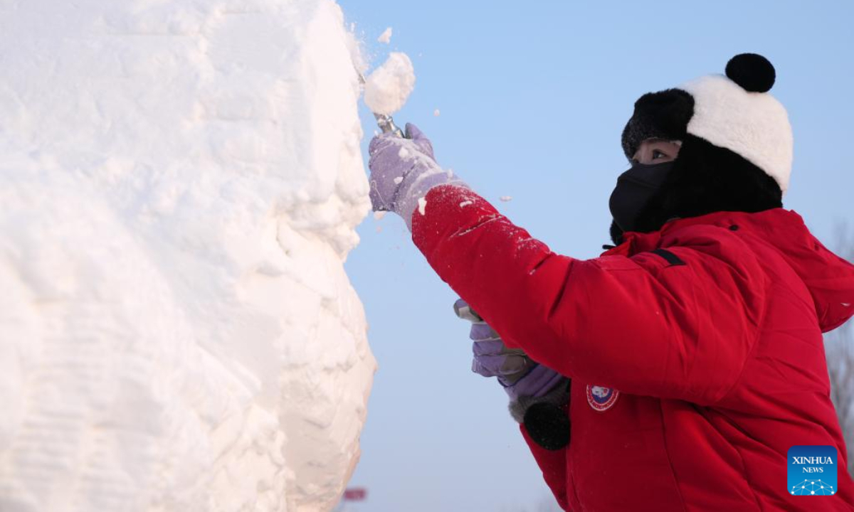 A contestant works on a snow sculpture at the 30th National Snow Sculpture Contest in Harbin, northeast China's Heilongjiang Province, Dec 28, 2023. Photo:Xinhua