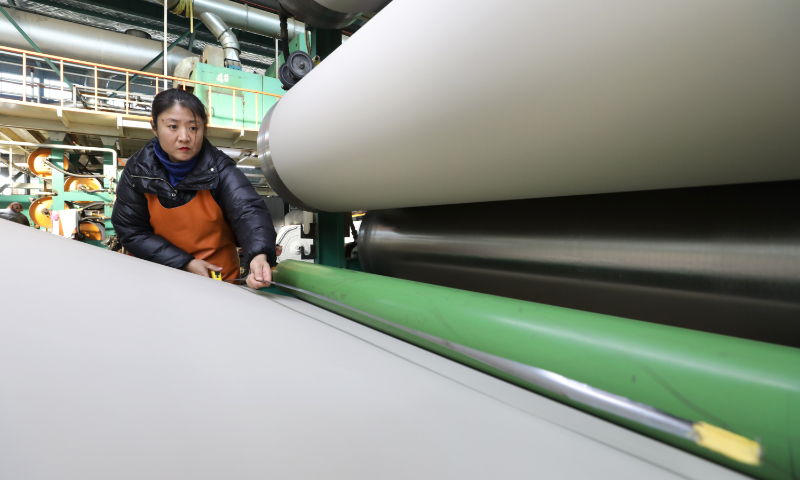A worker measures the width of leather at a factory in Jiaozuo, Central China’s Henan Province, on December 24, 2023. As the year comes to an end, companies in Jiaozuo are firing on all cylinders to catch up with orders for more sales. Photo: VCG