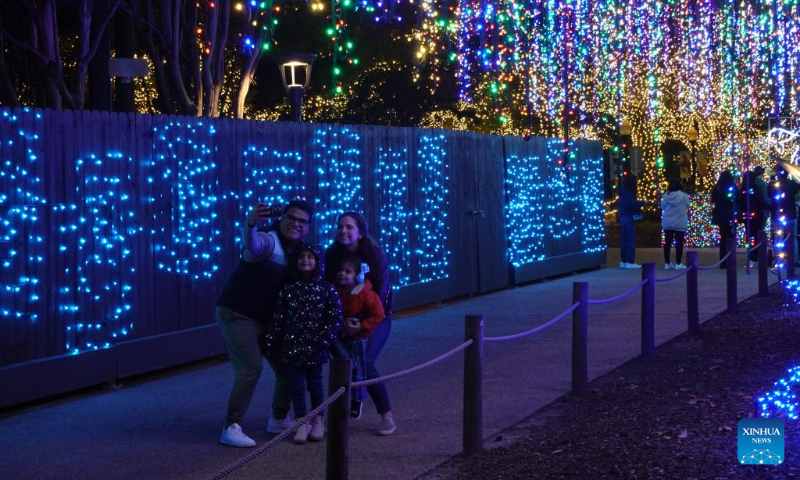 Visitors take selfies at the Houston Zoo Lights held in Houston, Texas, the United States, Dec. 30, 2023. The Houston Zoo Lights runs from Nov. 17, 2023 through Jan. 7, 2024. (Xinhua/Xu Jianmei)