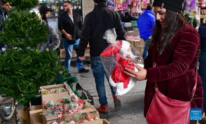 People are seen at a market of Christmas decorations in Damascus, Syria, Dec. 23, 2023. (Photo by Ammar Safarjalani/Xinhua)