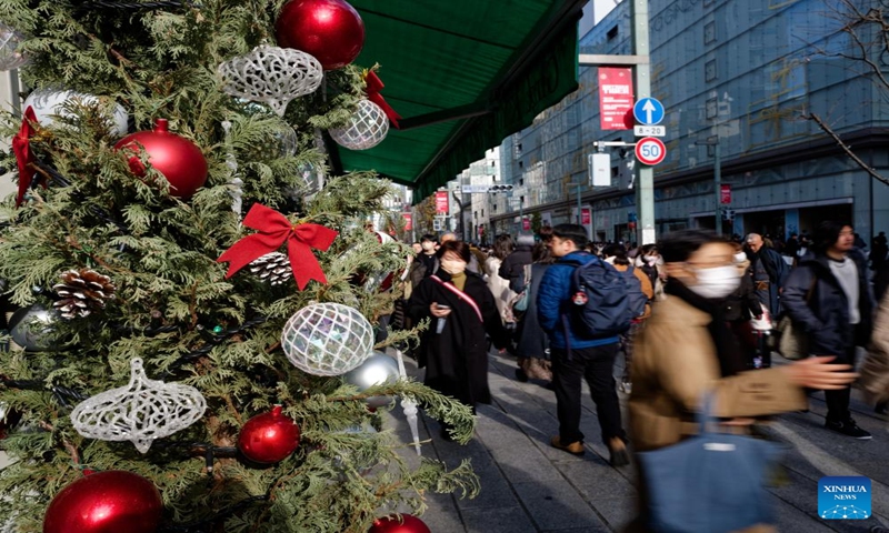 People walk past a Christmas tree in Ginza, Tokyo, Japan, Dec. 24, 2023. (Xinhua/Zhang Xiaoyu)