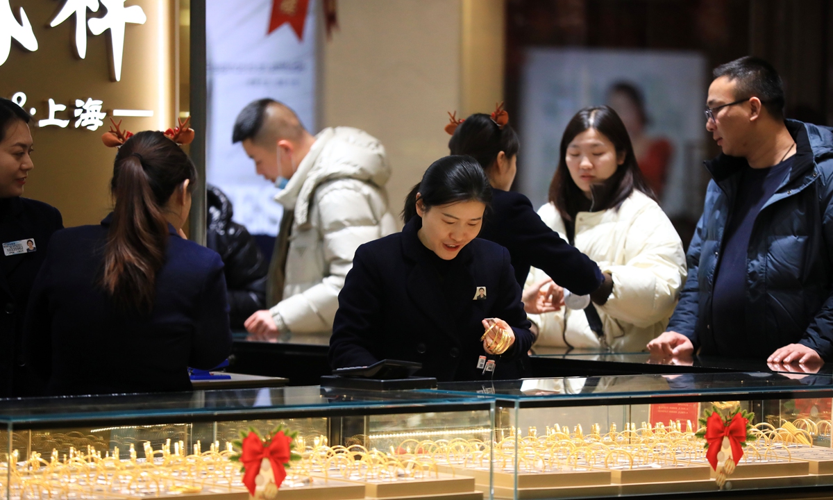 Customers shop for gold at a jewelry store in Huai'an, East China's Jiangsu Province on December 25, 2023. As the New Year and the Spring Festival holidays approach, gold and silver jewelry items are selling well across the country, despite high retail prices, which range from 570 yuan ($79.87) per gram to 590 yuan per gram. In the first 11 months of 2023, China's gold reserves reached 71.58 million troy ounces, up 380,000 troy ounces from October. Photo: VCG