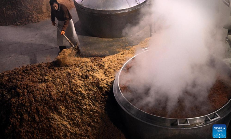 A worker is busy at a workshop of Baofeng Baijiu Co., LTD in Baofeng County, central China's Henan Province, Dec. 21, 2023. Baofeng County has a time-honored brewing industry of Baijiu (Chinese liquor), and is one of the birthplaces of traditional Chinese distilled liquor. Because of the suitable temperature, autumn and winter are the busiest time for local liquor production in a year.(Photo: Xinhua)