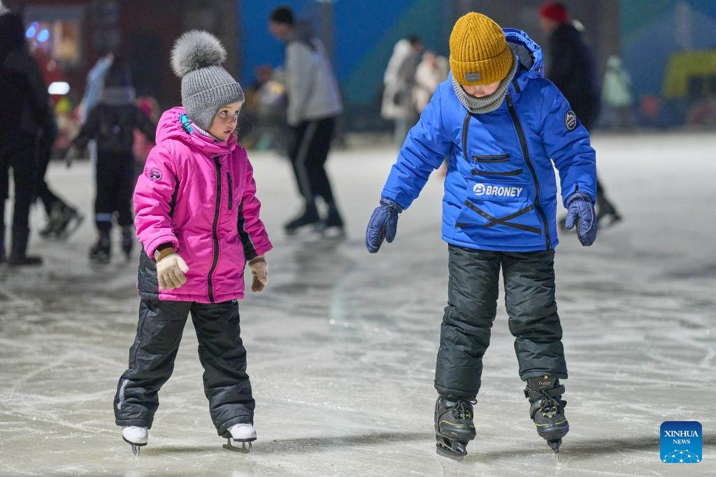 People skate at the Pioneer ice rink in Vladivostok, Russia, Dec. 25, 2023. Pioneer, the largest ice rink in Russia's Far East city of Vladivostok, opened to the public on Monday.(Photo: Xinhua)