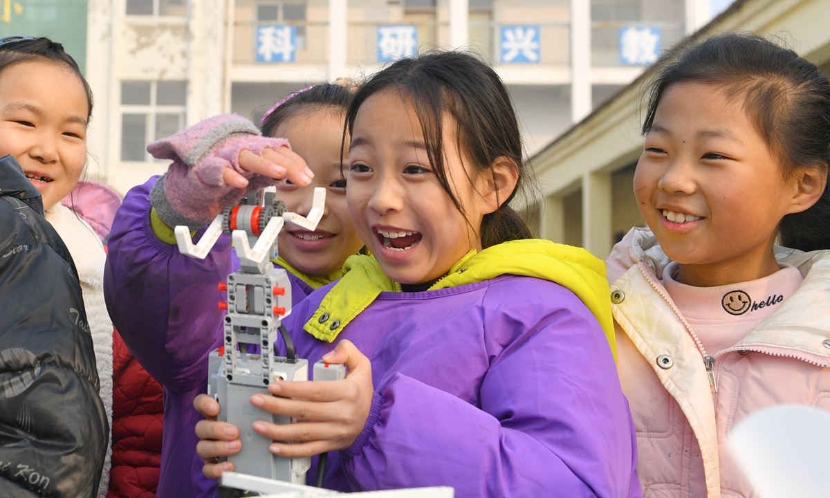 Students at a village school in Shangqiu, Central China's Henan Province play with model robots on December 27, 2023. China produced 3.53 million service robots that can be used in education, delivery and medical applications, in the first half of 2023, up 9.6 percent year-on-year, according to the Xinhua News Agency. Photo: VCG