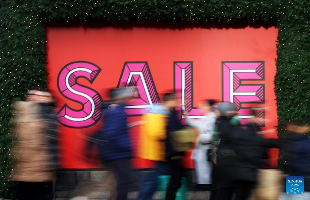 People walk past a sale sign outside a store during Boxing Day sales in London, Britain, on Dec. 26, 2023.(Photo: Xinhua)