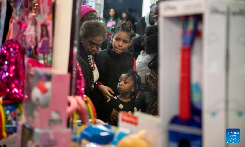 Children wait to pick out toys during the National Action Network (NAN) Christmas Dinner and Toy Distribution at the House of Justice in Harlem, New York, the United States, Dec. 25, 2023. NAN offered free meals and toys to local residents at the House of Justice in Harlem on Monday. (Photo: Xinhua)