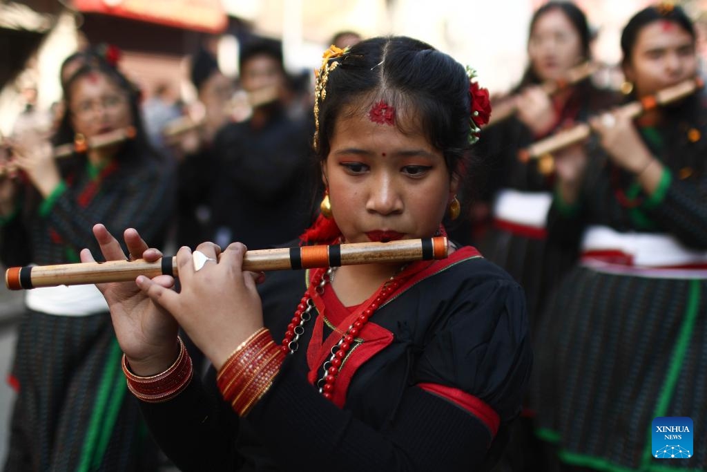 Girls in traditional attire play flutes during the celebration of Yomari Punhi in Kathmandu, Nepal, Dec. 26, 2023. Yomari Punhi is a festival especially celebrated by Newar community in Nepal to mark the end of the rice harvest on full moon day.(Photo: Xinhua)