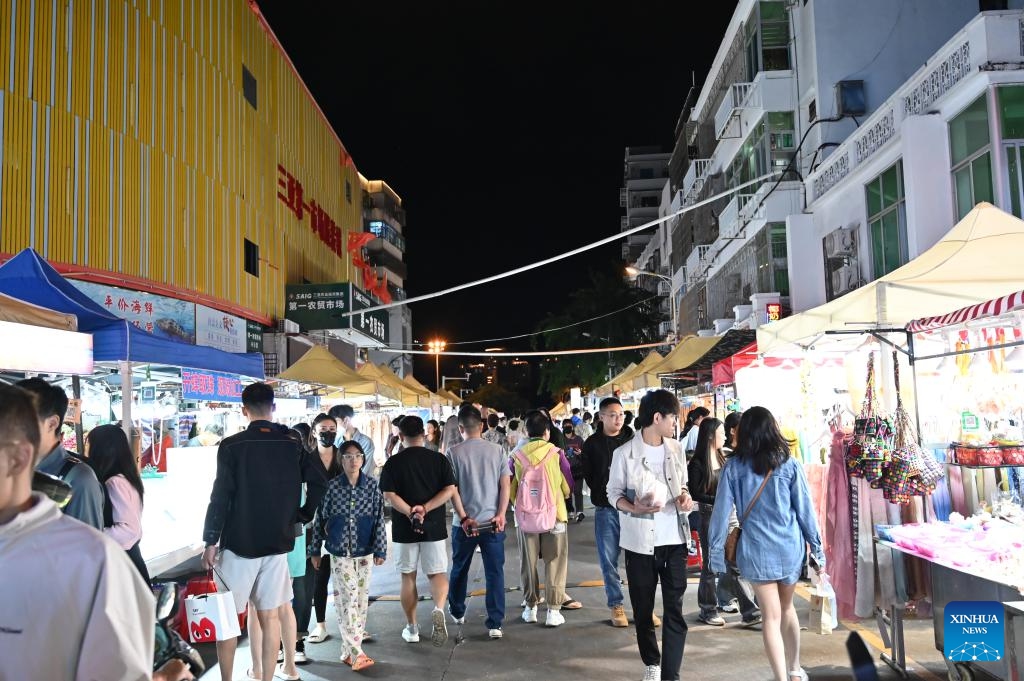 Tourists visit a night market in Tianya District of Sanya, south China's Hainan Province, Dec. 20, 2023. Since the beginning of winter, the tourism market in Sanya has been heating up continuously. According to official data, the city witnessed a peak season for tourism since mid-November, which is expected to last until the Spring Festival.(Photo: Xinhua)