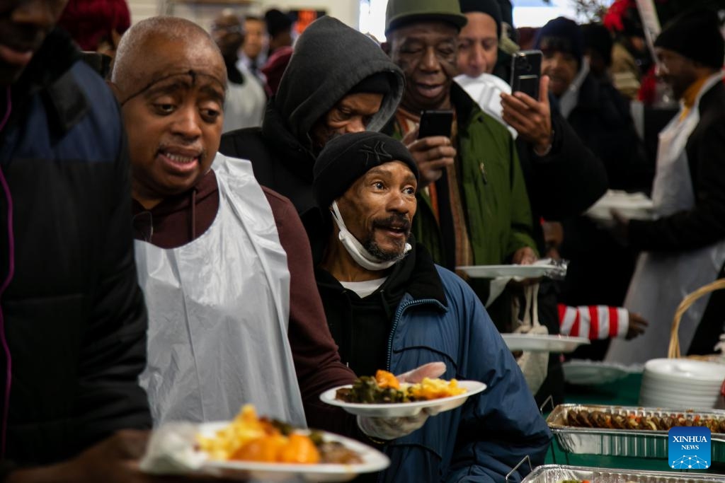 People are served food during the National Action Network (NAN) Christmas Dinner and Toy Distribution at the House of Justice in Harlem, New York, the United States, Dec. 25, 2023. NAN offered free meals and toys to local residents at the House of Justice in Harlem on Monday(Photo: Xinhua)