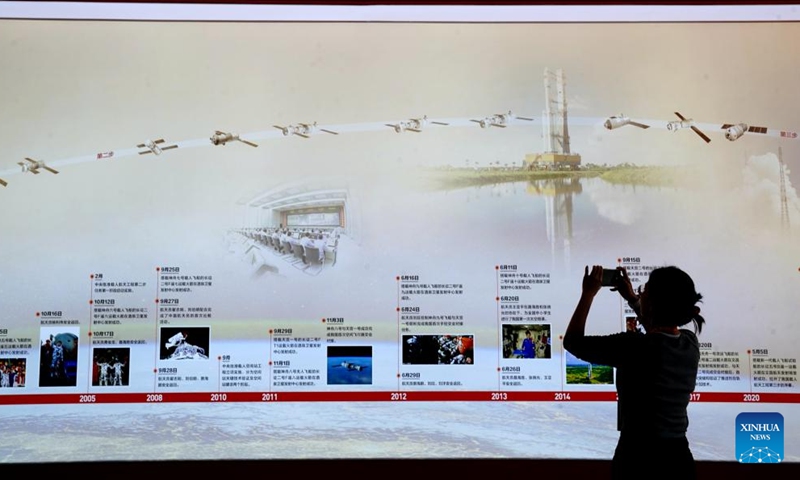 A visitor takes pictures at the Exhibition of Achievements in China Manned Space Program in Shanghai, east China, Dec. 29, 2023. The 50-day exhibition started at Shanghai New International Expo Center on Friday and it will be open to the public for free. (Photo: Xinhua)