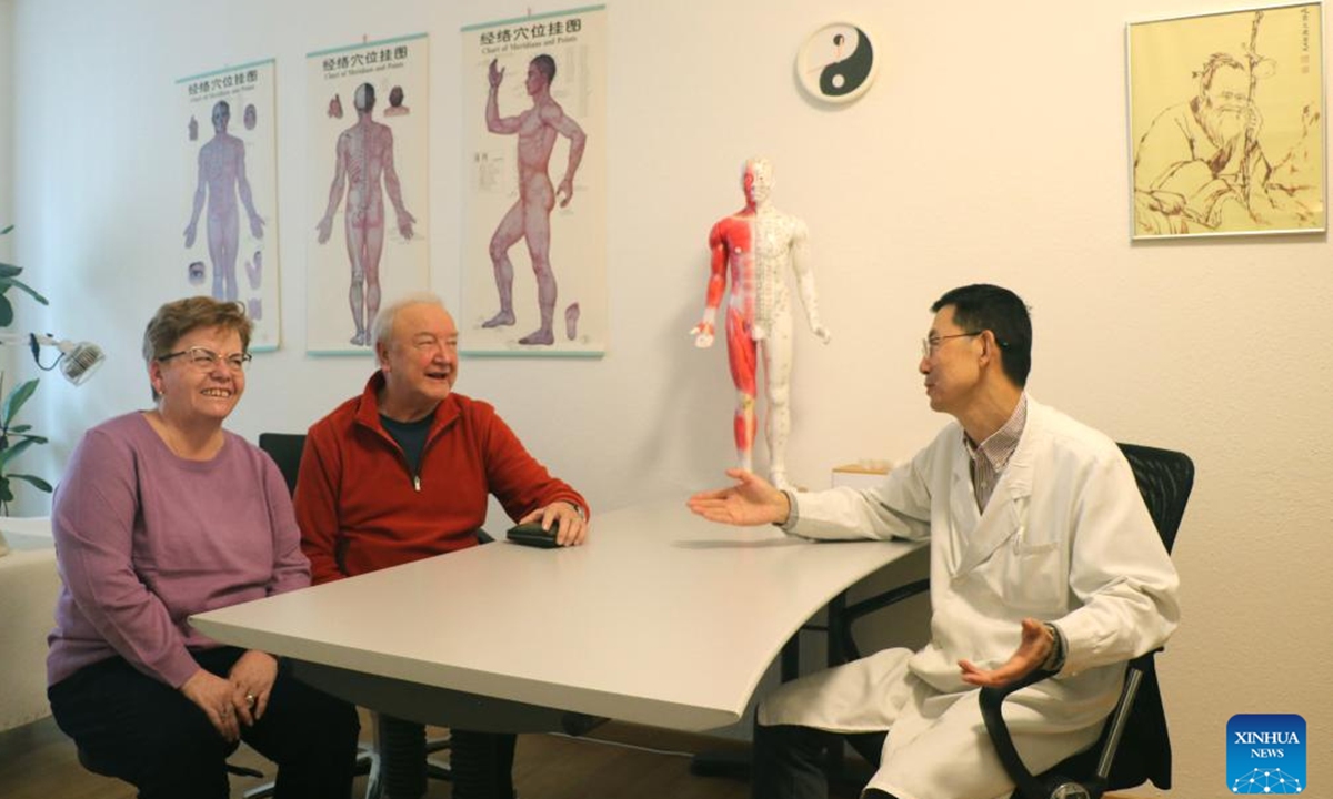 Practitioner Zhang Zhitai (R) communicates with his patient Mogel (C) after traditional Chinese medicine (TCM) treatment at the TCM-City clinic in Schaffhausen, Switzerland, Dec. 11, 2023. (Photo: Xinhua)