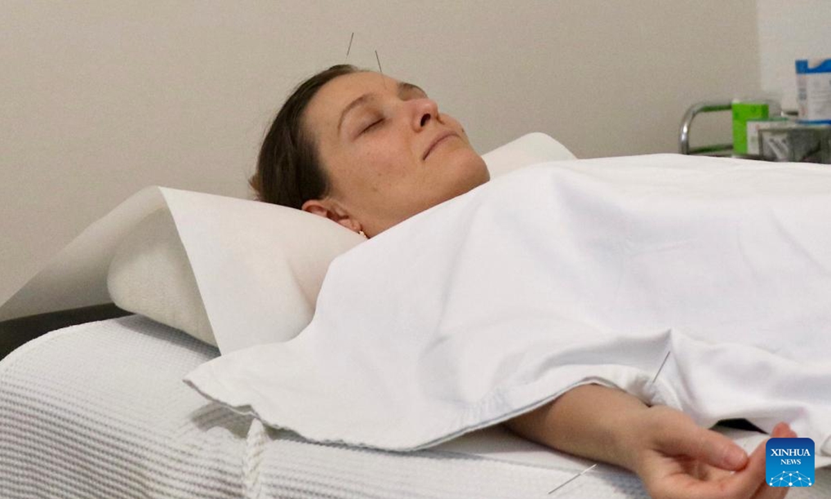 Patient Miroslava receives acupuncture therapy at the TCM-City clinic in Schaffhausen, Switzerland, Dec. 11, 2023. (Photo: Xinhua)