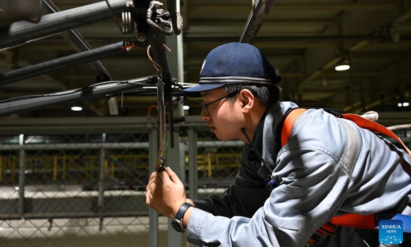 A staff member checks the pantograph of a high-speed electrical multiple unit (EMU) train at a maintenance station in Hohhot, north China's Inner Mongolia Autonomous Region, Jan. 2, 2024. Staff members at the maintenance station were busy servicing the EMU trains on Tuesday so as to guarantee their normal operations after the New Year holiday travel rush. (Photo: Xinhua)