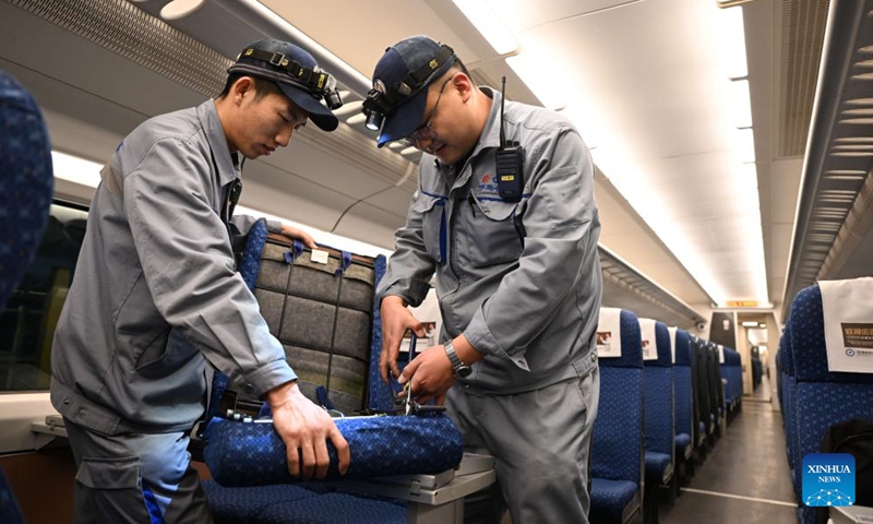 Staff members repair a damaged chair on a high-speed electrical multiple unit (EMU) train at a maintenance station in Hohhot, north China's Inner Mongolia Autonomous Region, Jan. 2, 2024. Staff members at the maintenance station were busy servicing the EMU trains on Tuesday so as to guarantee their normal operations after the New Year holiday travel rush. (Photo: Xinhua)