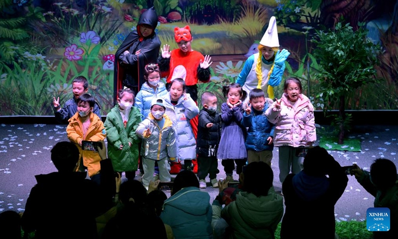 Children pose with artists after a child play at a theater in Xi'an, northwest China's Shaanxi Province, Jan. 1, 2024. Dramas, concerts and shows for children were staged during the New Year holiday in the northwestern city of Xi'an. (Photo:Xinhua)