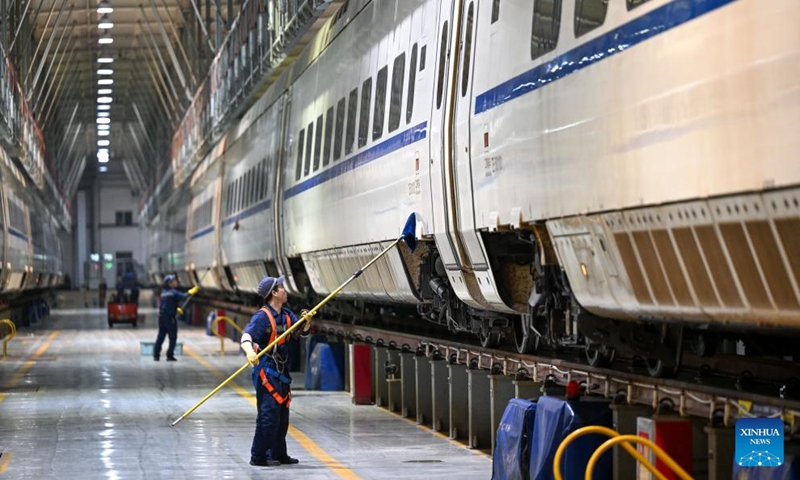 Staff members clean the exterior of a high-speed electrical multiple unit (EMU) train at a maintenance station in Hohhot, north China's Inner Mongolia Autonomous Region, Jan. 2, 2024. Staff members at the maintenance station were busy servicing the EMU trains on Tuesday so as to guarantee their normal operations after the New Year holiday travel rush. (Photo: Xinhua)