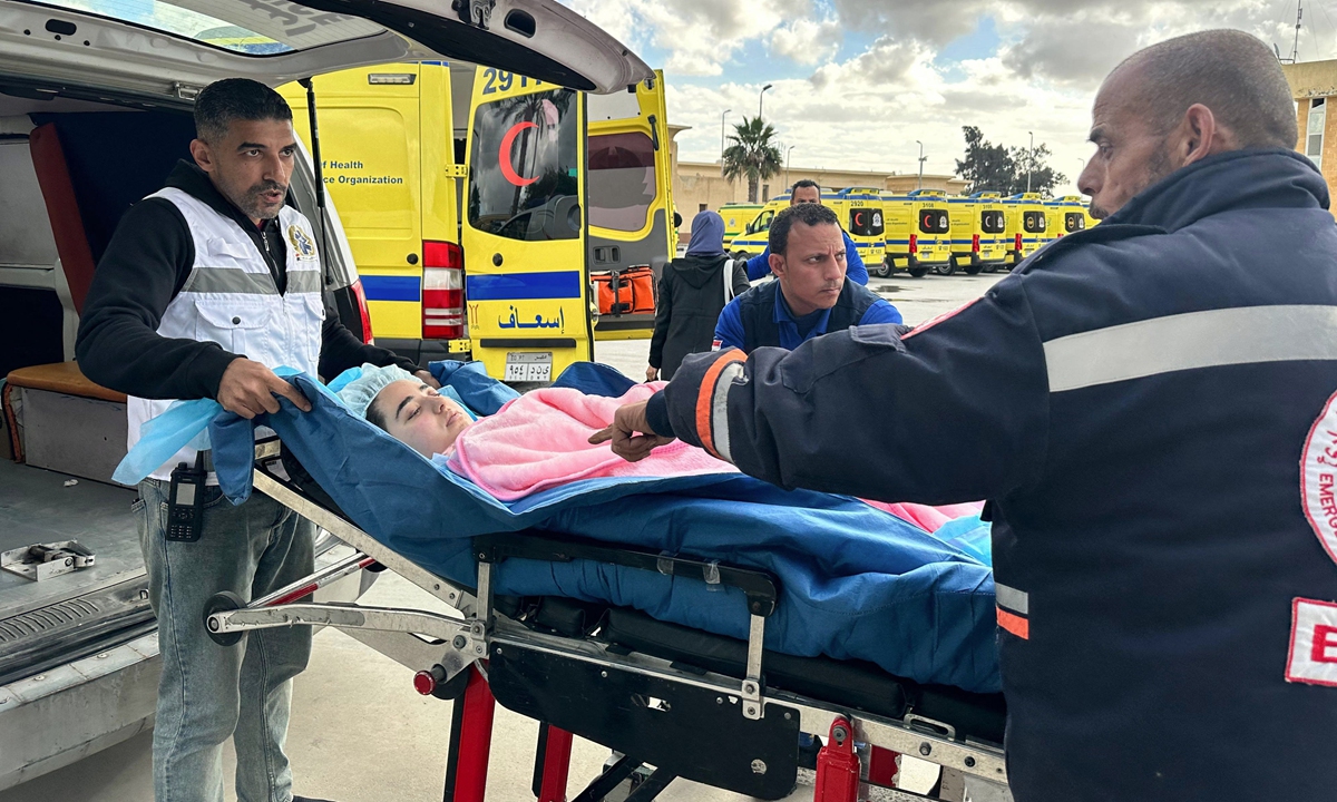 An injured Palestinian child is transferred by Egyptian paramedics into an ambulance, after being allowed to be evacuated from the Gaza Strip via the Rafah crossing on January 14, 2024. The day marks the 100th day since the war broke out between Israel and Hamas on October 7, 2023.  Photo: VCG