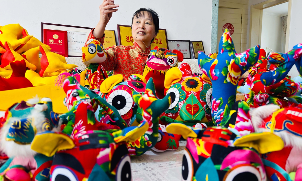 Sun Xiulan, a folk artist who specializes in Weifang cloth toys, crafts traditional fabric creations in Weifang, East China's Shandong Province on January 3, 2024. Admired for their concise designs, strong decorative elements, vivid colors and rich folk art style, these meticulously crafted cloth toys depicting zodiac animals like tigers and dragons are treasured by consumers. Folk artists are rushing to produce these charming cloth toys to meet the demand for the upcoming Spring Festival holidays. Photo: VCG