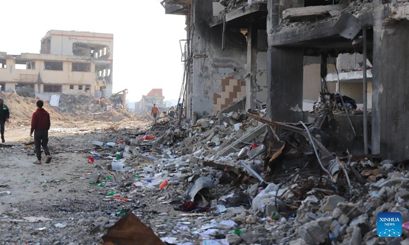 People walk past destroyed buildings in Gaza City, on Jan. 2, 2024. The death toll of Palestinians has exceeded 22,000 after the outbreak of the Israel-Hamas conflict on Oct. 7, 2023, the Hamas-run Health Ministry said on Tuesday.(Photo: Xinhua)