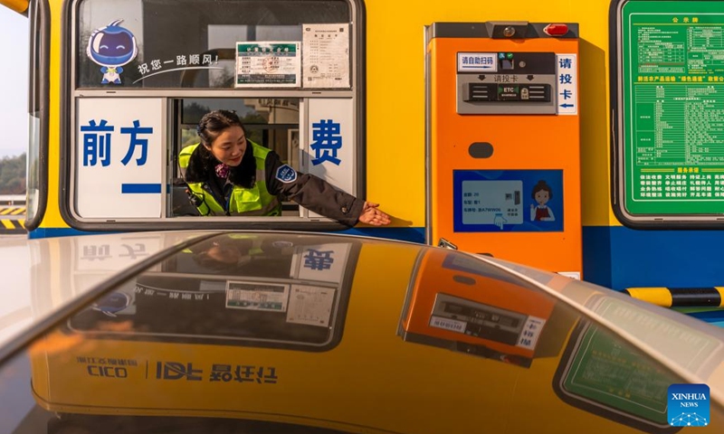 A staff member gestures as a car passes an expressway toll gate in east China's Zhejiang Province, Jan. 2, 2024. Workers around China have returned to their respective posts after the New Year holiday. (Photo: Xinhua)