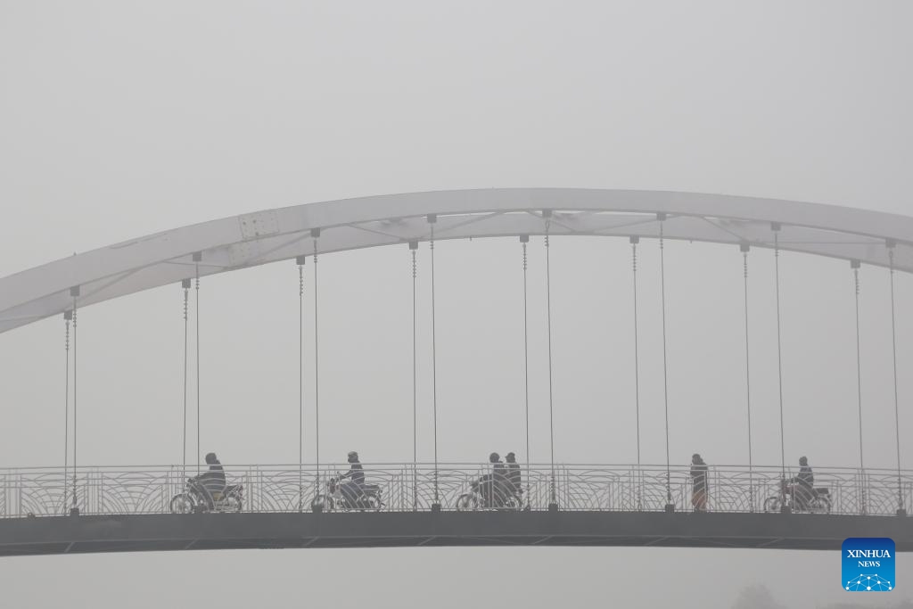 Commuters ride motorbikes amid heavy fog over a footbridge in Islamabad, capital of Pakistan on Jan. 3, 2024. Dense fog in Islamabad and adjacent areas has disrupted bus, train and flight schedules, local media reported.(Photo: Xinhua)