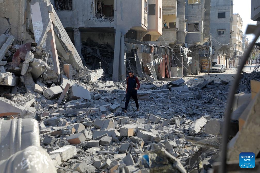 A man walks among the rubble of buildings destroyed in Israeli strikes in the southern Gaza Strip city of Khan Younis, on Jan. 4, 2024. Palestinian death toll from Israeli strikes on the Gaza Strip rose to 22,438 since the Israel-Hamas conflict broke out on Oct. 7, 2023, said the Gaza-based Health Ministry on Thursday.(Photo: Xinhua)