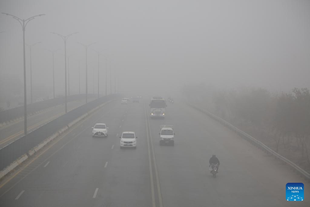 Vehicles move amid heavy fog on a road in Islamabad, capital of Pakistan on Jan. 3, 2024. Dense fog in Islamabad and adjacent areas has disrupted bus, train and flight schedules, local media reported.(Photo: Xinhua)