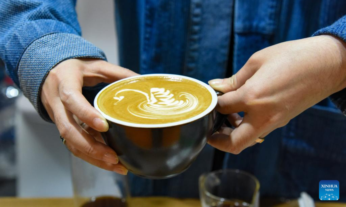 An exhibitor shows a cup of coffee during China (Pu'er) International Coffee Expo in Pu'er, southwest China's Yunnan Province, Jan 5, 2024. Photo:Xinhua