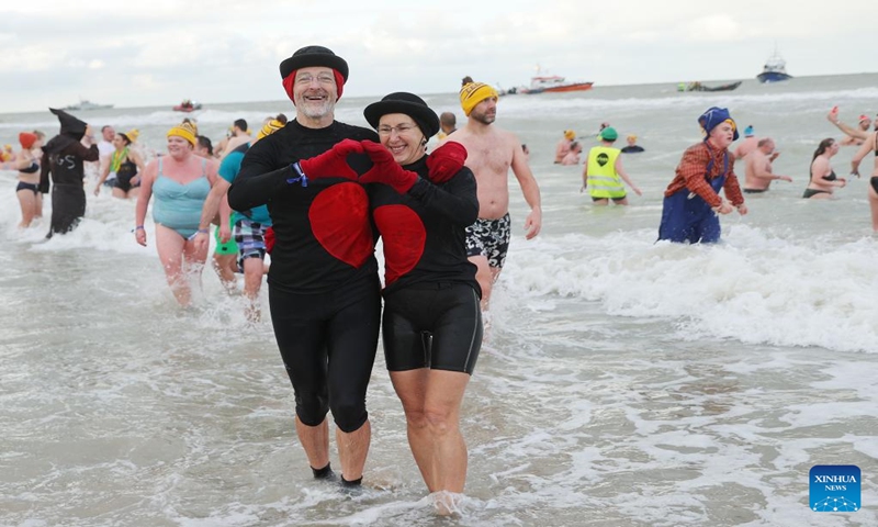 People pose for photos during the traditional New Year's Dive in Ostend, Belgium, Jan. 6, 2024. Thousands of people braved the cold North Sea on Saturday to welcome the New Year. (Xinhua/Zhao Dingzhe)